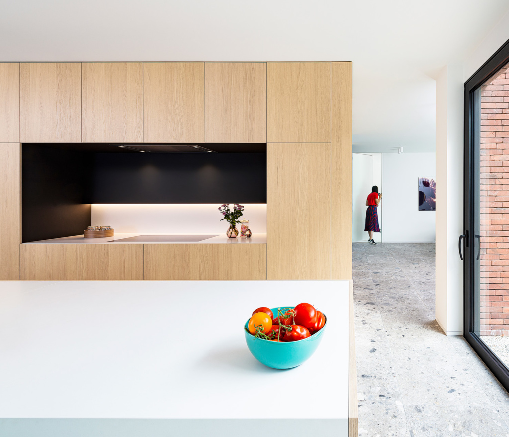 Keuken met eik fineer deuren witte en zwarte accenten inductievuur gelinkt aan dampkap
