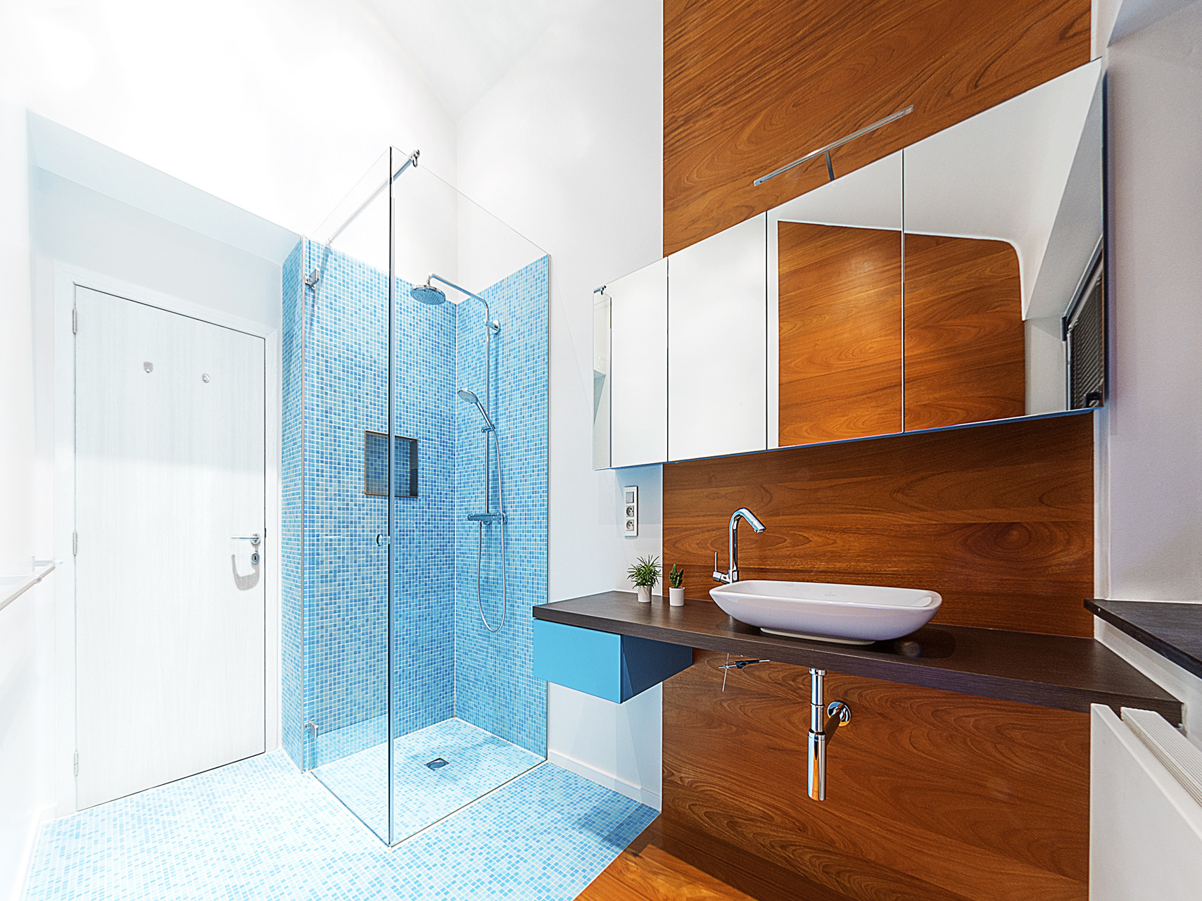 Compacte badkamer Tienen combinatie mozaïek-tegeltjes met warme parket douche met randloze glazen wanden strak wastafeltje moderne pompbak