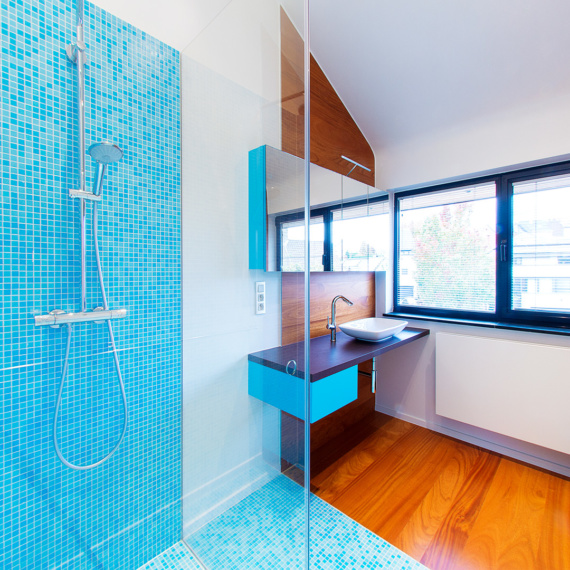 Compacte badkamer Tienen combinatie mozaïek-tegeltjes met warme parket douche met randloze glazen wanden strak wastafeltje moderne pompbak