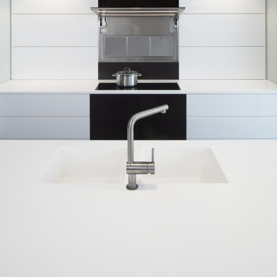 Strakke monochrome moderne keuken met ingebouwde dampkap afzuigsysteem in wand