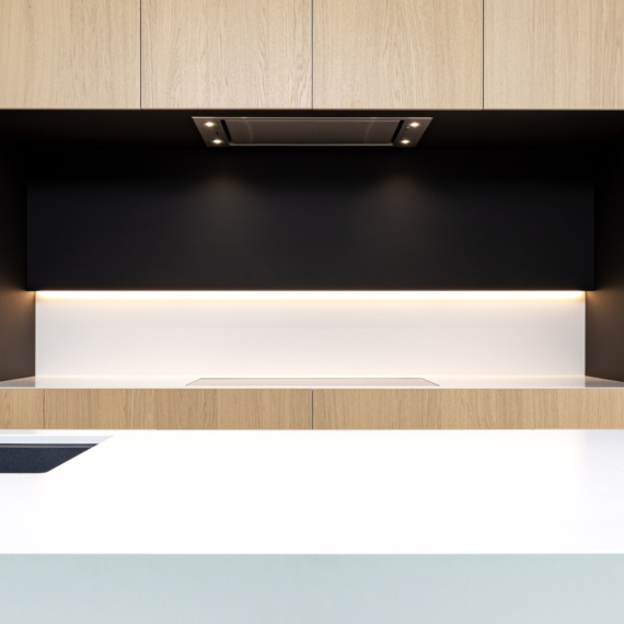 Keuken met eik fineer deuren witte en zwarte accenten inductievuur gelinkt aan dampkap