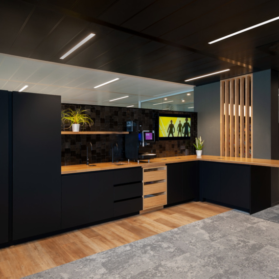 grote open keuken in kantoren van DPG media mat zwarte afwerking met eiken keukenblad en eiken roomdivider